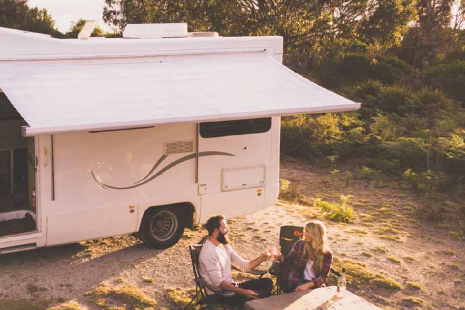 couple sitting outside motorhome awning