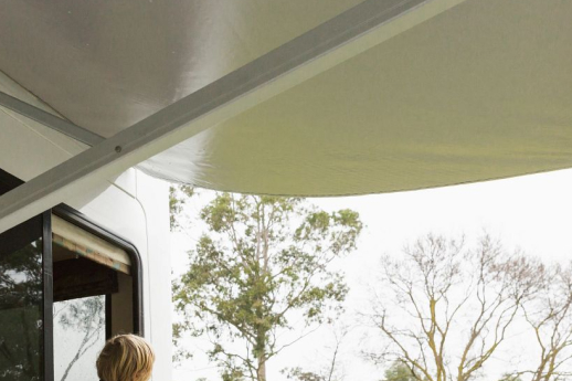  boy looking out motorhome window at awning that is out