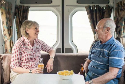 Couple sitting in lounge at the back of motorhome